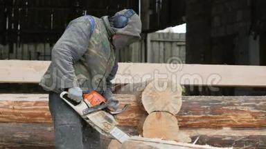 建筑工人为未来的家砍柴电锯。 建筑工人头上戴防护面罩和耳机